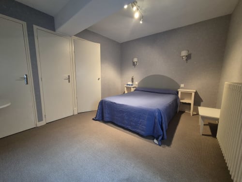 Chambre double moderne à l'Hôtel Saint Jean à Chalon sur Saône avec literie bleue, murs beige et mobilier contemporain
