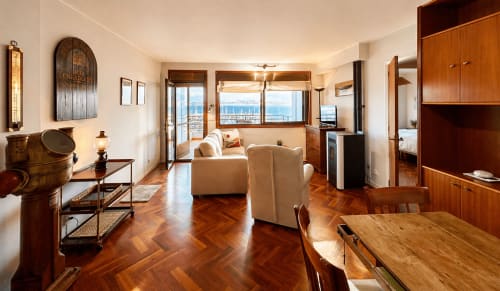 Apartamento Bitácora en Baiona con vistas al mar, suelos de parqué en espiga, sofá crema, mesa de comedor y equipamientos modernos
