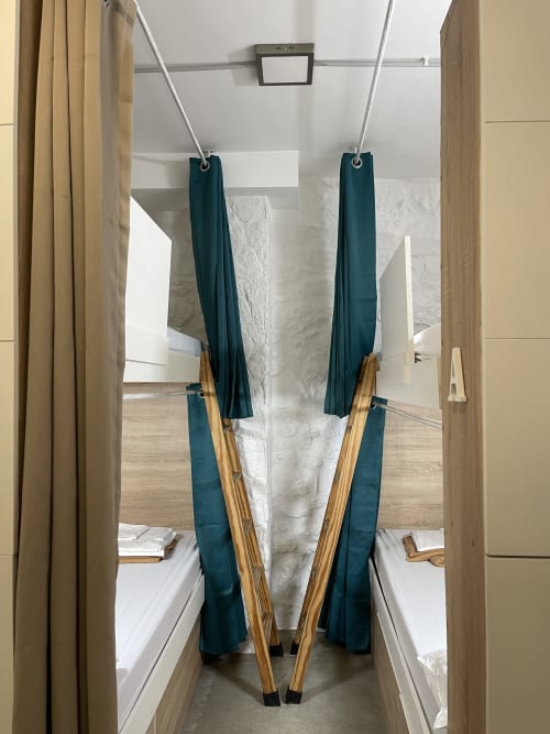 Habitación compartida de cuatro camas en Therma Pilgrim Hostel en Caldas de Reis con cortinas turquesas y marcos de madera