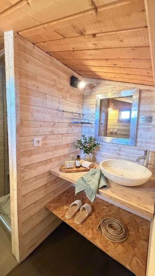 Bagno rustico con lavabo rotondo, specchio e arredamento costiero presso l'hotel Le Maquis Plage