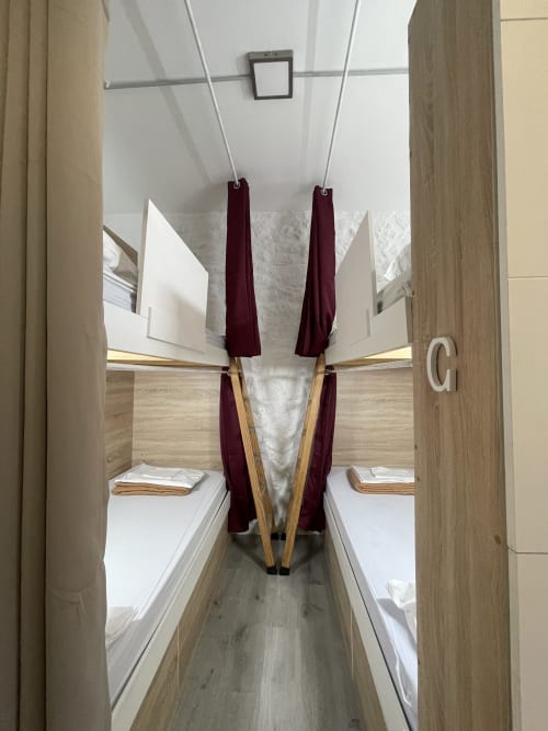 Dormitorio compartido mixto con 4 literas y cortinas burdeos en Therma Pilgrim Hostel, Caldas de Reis