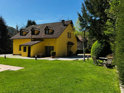 Vila groga El Niu de l'Aguila a Camprodon amb jardí cuitat, gespa verda i vistes a les muntanyes