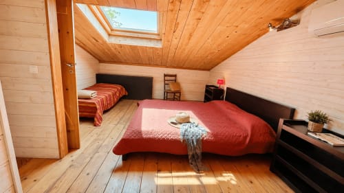 Chambre mansardée chaleureuse avec puits de lumière et literie rouge au Maquis Plage à Poggio-Mezzana