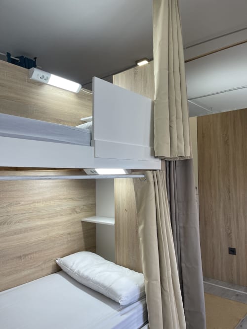 Moderno dormitorio compartido mixto en el Hostel Therma Pilgrim, Caldas de Reis, con camas litera, paneles de madera y privacidad