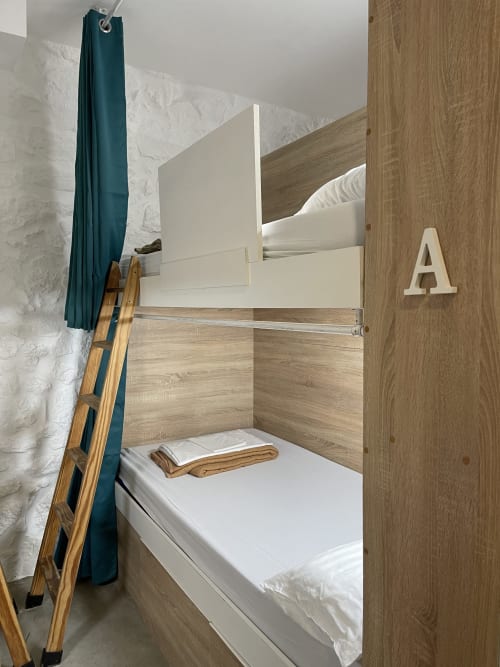 Cama litera con estructura de madera y ropa blanca en dormitorio compartido del Therma Pilgrim Hostel, Caldas de Reis