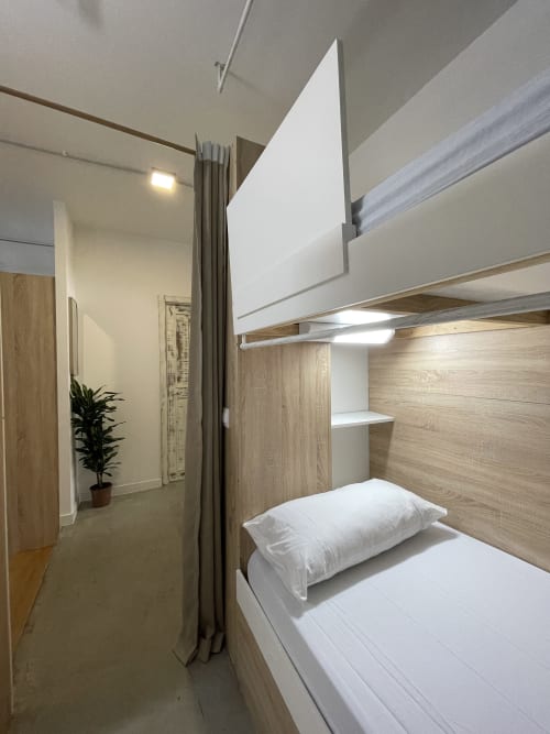Cama litera moderna en habitación compartida de Therma Pilgrim Hostel, Caldas de Reis, con detalles de madera y ropa de cama blanca