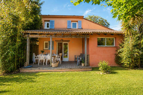 Hotel Le Maquis Plage a Poggio-Mezzana con facciata in cotto arancio, terrazza in legno e giardino curato