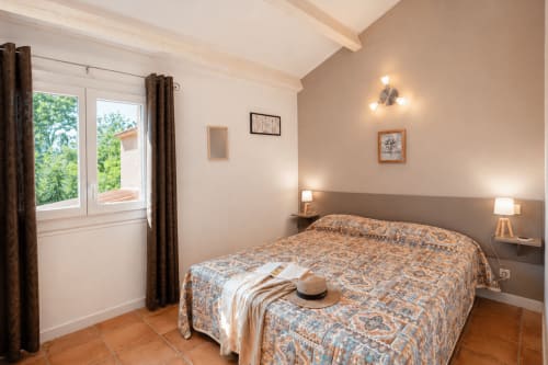 Chambre lumineuse à la villa Le Maquis Plage à Poggio-Mezzana avec lit queen-size, tables de nuit, vue sur le jardin