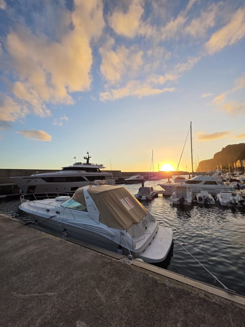 Marina al atardecer con barcos amarrados y veleros en Calheta, Portugal, cerca del hotel Les Terrasses Les Suites