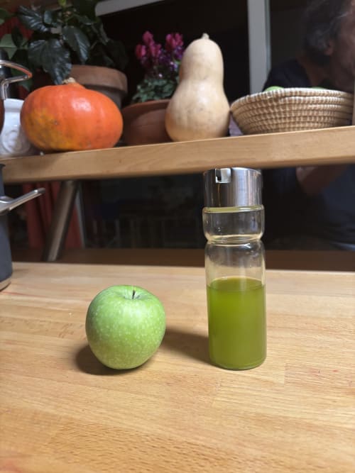 Mela verde fresca e succo di mela sul tavolo di legno a Casale Artemisia, Capalbio Toscana