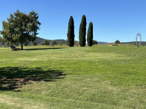 Exuberante césped verde en Casale Artemisia con cipreses y colinas ondulantes, Capalbio