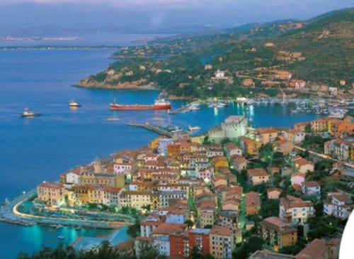 Villaggio costiero di Capalbio con edifici colorati, porto e Mar Mediterraneo vicino a Casale Artemisia