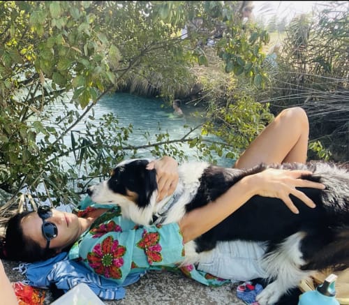 Donna che si rilassa con cane presso la laguna turchese di Casale Artemisia, Capalbio