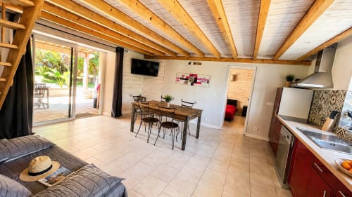 Monolocale open-plan Le Maquis Plage con travi in legno, cucina, zona pranzo e vista mare a Poggio-Mezzana