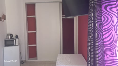 Quarto moderno da AL Hospedaria Pôr do Sol em Olhão com guarda-roupa deslizante, TV e iluminação neon roxo