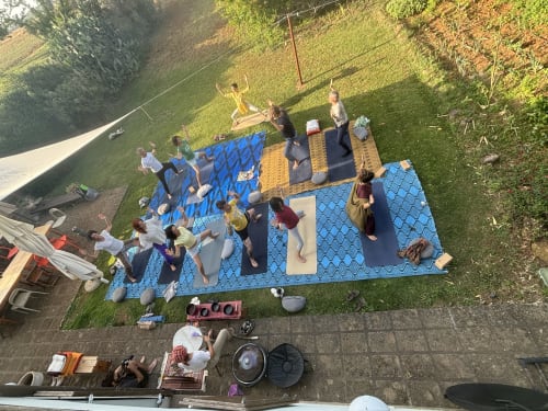 Los huéspedes disfrutan de una clase de yoga al aire libre en colchoneta azul en Casale Artemisia B&B en Capalbio, Toscana