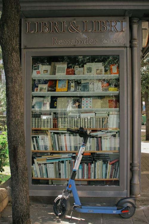 Casetta di scambio libri 'Libri & Libri' presso Casale Artemisia a Capalbio con scooter blu parcheggiato all'esterno
