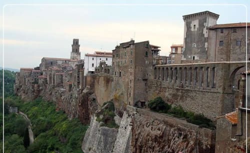 Villaggio medievale di Capalbio arroccato su scogliera con vista sulla valle, torri storiche e architettura in pietra