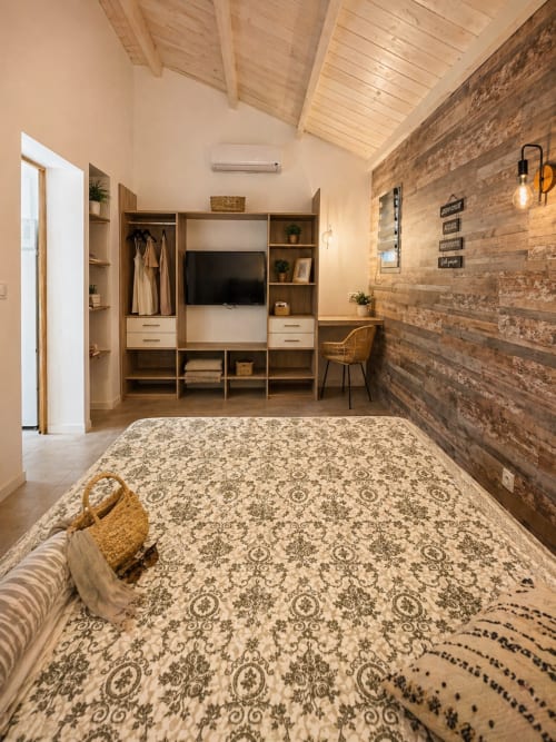 Modern bedroom at Le Maquis Plage with wooden accent wall, built-in storage, and patterned bedding
