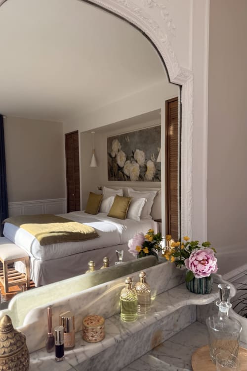 Luxury bedroom at La Maison 1680 in Couches with marble vanity, white linens, and garden flowers