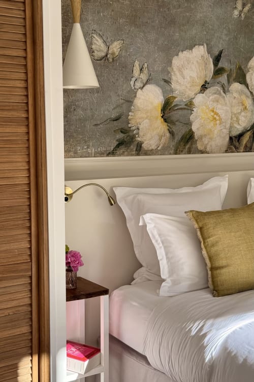 La chambre de Marguerite at La Maison 1680 with white peonies wallpaper, garden view, and white bedding with green pillow