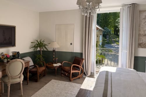 La chambre de Jeanne at La Maison 1680 in Couches features elegant seating, green wainscoting, and garden views through