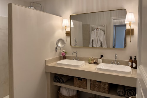 Modern bathroom at La Maison 1680 B&B in Couches, France with dual vanities, mirrors, and elegant lighting fixtures
