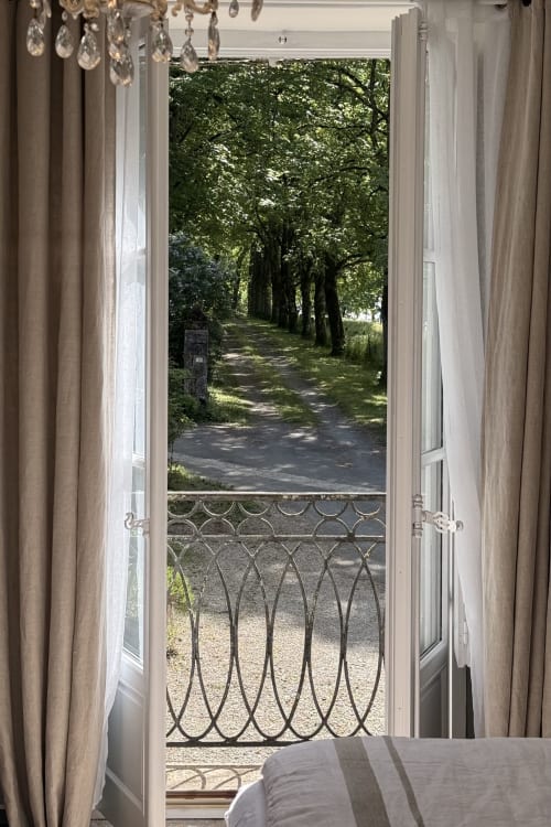 Open French doors overlooking tree-lined garden path at La Maison 1680 in Couches