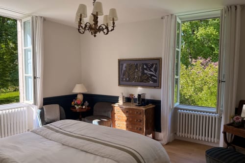 Elegant bedroom at La Maison 1680 in Couches with garden views, wooden furniture, and modern amenities