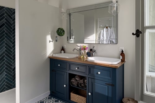 Modern dual-sink bathroom vanity with navy cabinetry at La Maison 1680 B&B in Couches, France