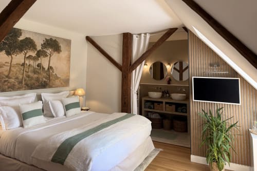 Rustic bedroom at La Maison 1680 in Couches with exposed beams, white bedding, and en-suite bathroom with garden view