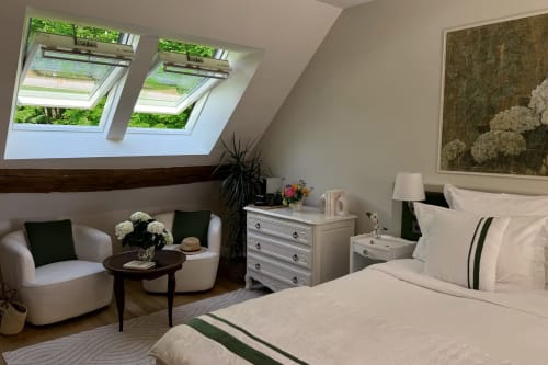 Elegant bedroom at La Maison 1680 with skylight, seating area, and garden views in Couches