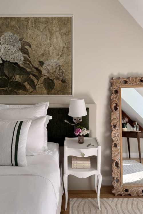 Elegant bedroom at La Maison 1680 with white bedding, vintage floral artwork, ornate mirror, and garden views in Couches,