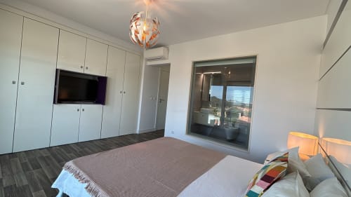 Quarto moderno na villa Casa Cliff, Sesimbra com cama, TV de tela plana, guarda-roupas embutidos e varanda com vista para o mar