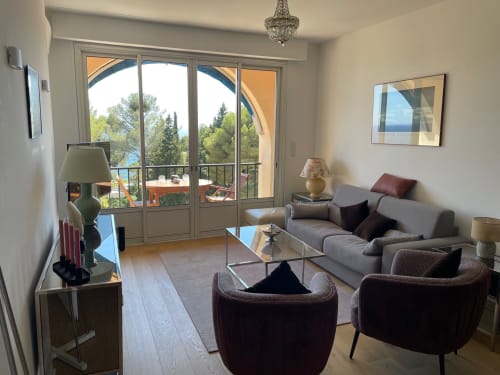Modern apartment living room at Résidence Le Château Du Parc in Saint Raphaël with sea view balcony, gray sofa, and