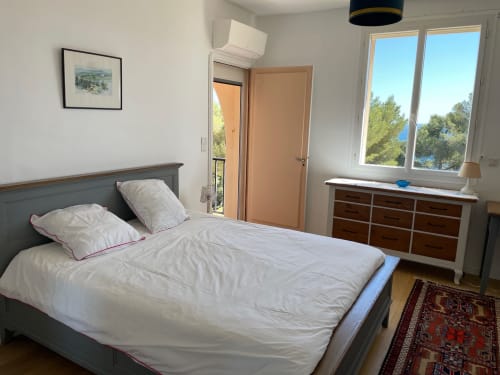Bright bedroom with sea view at Résidence Le Château Du Parc, Saint Raphaël, featuring double bed, dresser, and balcony doors