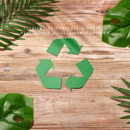 Symbole de recyclage vert avec feuilles tropicales sur fond en bois promouvant le tourisme durable à l'Hôtel Mas le Châtelet