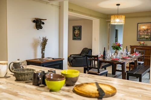 Salle à manger du Gîte La Combe avec table en bois, couverts dressés et coin salon au Domaine Sur-Valot