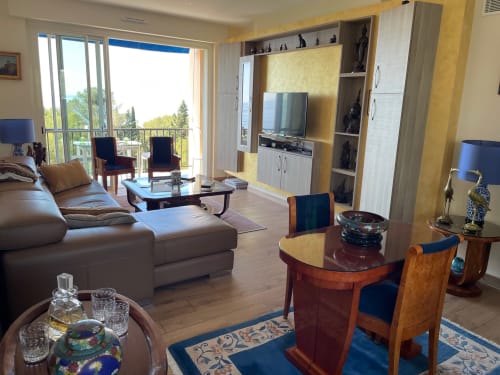 Luxury apartment living room with sea view balcony, dining area, flat-screen TV, and modern furnishings at Résidence Le
