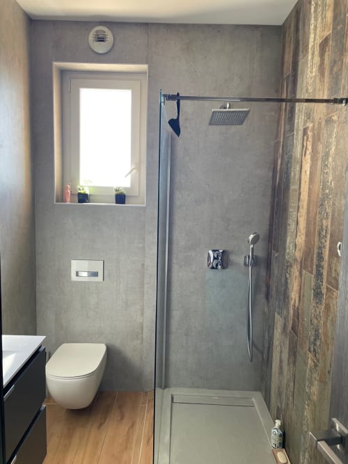 Modern bathroom in Résidence Le Château Du Parc with walk-in shower, toilet, and window at Saint Raphaël apartment