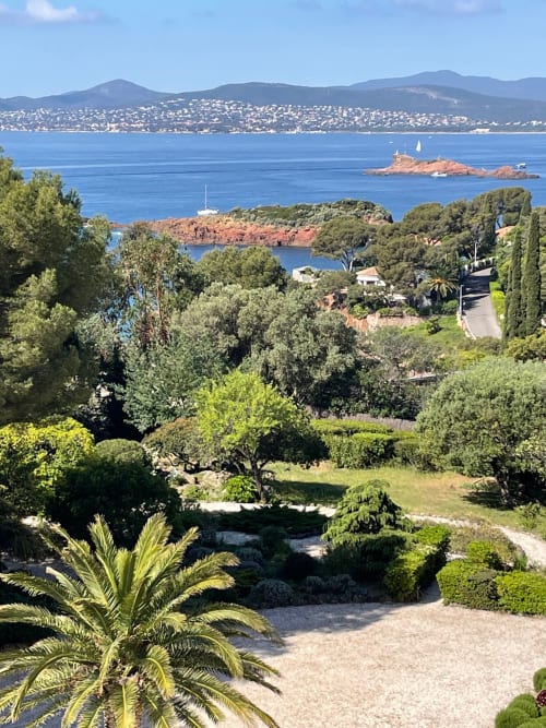 Mediterranean sea view from Saint Raphaël apartment with lush gardens, sailboats, and coastal hills