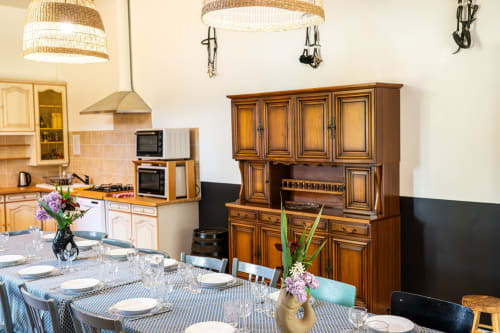 Salle à manger du Gîte L'Écurie au Domaine Sur-Valot avec mobilier en bois et table dressée