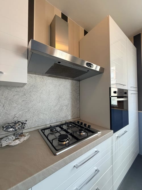 Modern kitchen in Cinelli Apartment with gas cooktop, stainless steel range hood, and light cabinetry