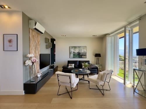Salon moderne SoleMare à Alata avec canapé noir, baies vitrées et vue sur mer