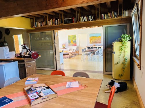 Amplio comedor de concepto abierto en Casale Artemisia B&B en Capalbio con mesa de madera, estanterías y perro