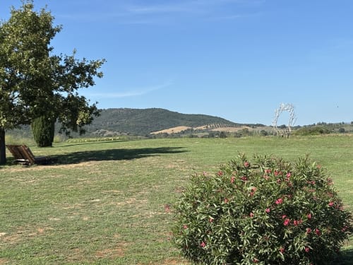 Casale Artemisia en la campiña toscana con flores en floración, césped verde y colinas ondulantes cerca de Capalbio, Toscana Italia