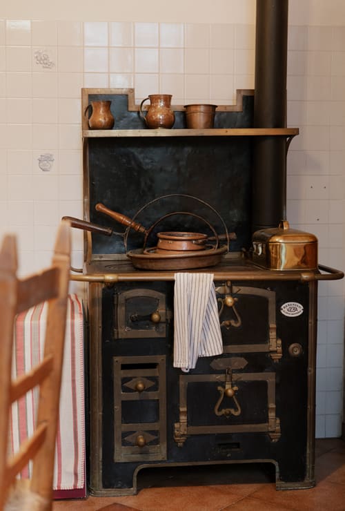 Vintage wood-burning stove with copper cookware at Cristallo Apartment, Ravenna