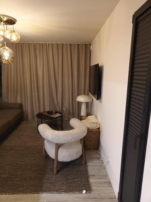Intérieur moderne de l'appartement CIRELINE-La Fontaine du Roy, Rognes, avec fauteuil crème, télévision et luminaires suspendus