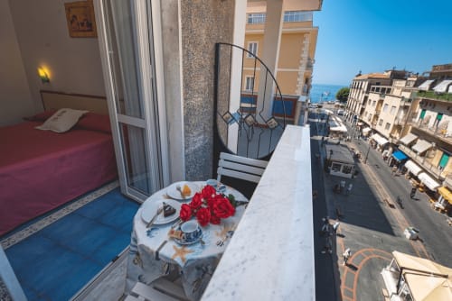 Balcone con rose rosse e tavolo apparecchiato con vista sulla strada di Maiori presso Casa Mannini B&B, Italia