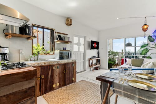 Modern oceanfront cottage kitchen and living area with wooden cabinetry, sea views, and comfortable seating in Isla Mujeres